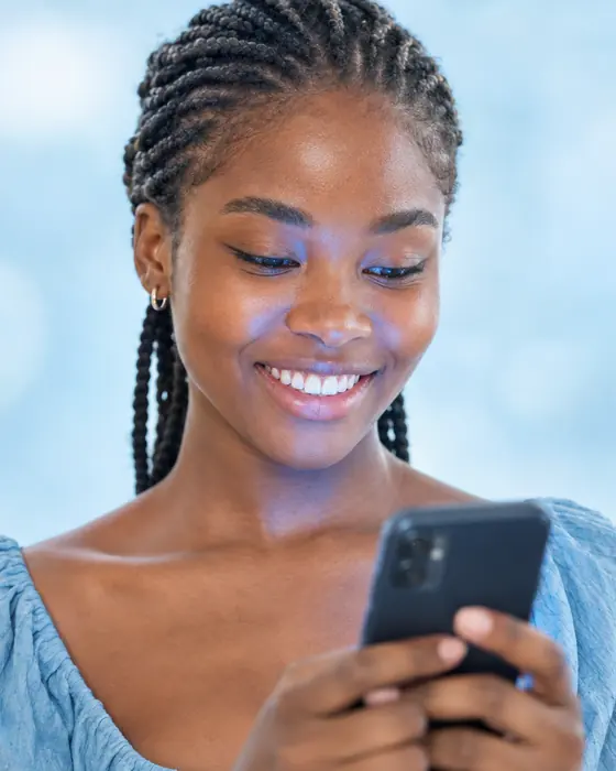 A young woman smiling at her smartphone