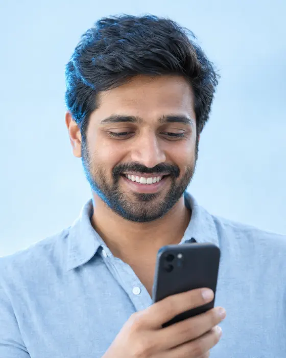 A man smiling at his smartphone